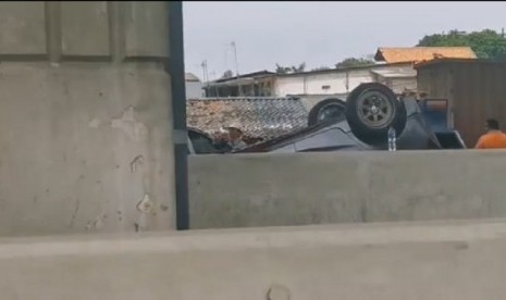 Sebuah mobil terguling di Tol Layang Jakarta Cikampek (Japek) Kilometer 14, Kamis (19/12).