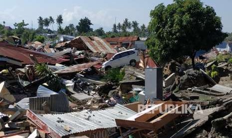 Sebuah mobil terhempas di antara reruntuhan rumah di Perumnas Bala Roa, Palu, Ahad (30/9).