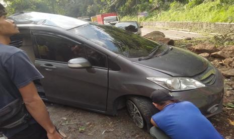 Sebuah mobil tertimpa longsor yang terjadi di Jl Raya Cadas Pangeran Kabupaten Sumedang.