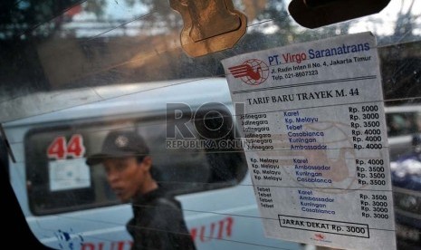  Sebuah pengumuman tarif baru angkutan umum tertempel di salah satu mobil angkutan di kawasan Kampung Melayu, Jakarta.     (Republika/Prayogi)