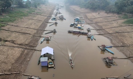 Sebuah perahu bermotor kecil (ces) melewati kawasan Sungai Teweh (anak Sungai Barito) yang menyempit akibat penurunan debit air di kawasan Kelurahan Jambu, Kecamatan Teweh Baru, Kabupaten Barito Utara, Kalimantan Tengah. (ilustrasi) 