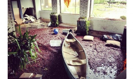  Sebuah perahu masuk ke sebuah rumah setelah terjadinya Badai Sandy di Brooklyn, New York, Selasa (30/10).  (Lucas Jackson/Reuters)