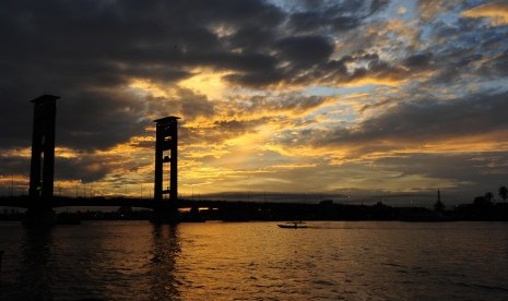 Sebuah perahu melintasi Jembatan Ampera di Palembang, Senin (7/3).