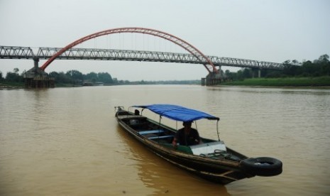 Sebuah perahu motor melintasi Sungai Kahayan yang diselimuti asap tipis di Palangka Raya, Kalimantan Tengah, Kamis (29/10).