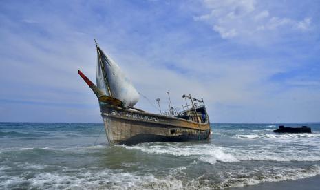 Sebuah perahu yang digunakan untuk mengangkut etnis Rohingya terdampar di pantai Indra Patra di desa Ladong, provinsi Aceh, Indonesia, Minggu, 25 Desember 2022. Perahu kayu yang membawa puluhan Muslim Rohingya itu mendarat di provinsi paling utara itu pada Minggu.