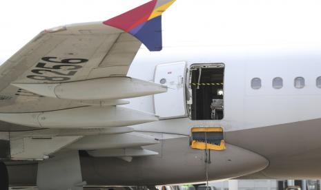 Sebuah pesawat Asiana Airlines terparkir saat salah satu pintu pesawat tiba-tiba terbuka di Bandara Internasional Daegu di Daegu, Korea Selatan, Jumat, 26 Mei 2023. Seorang penumpang membuka pintu pada penerbangan Asiana Airlines yang kemudian mendarat dengan selamat.