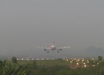 Sebuah pesawat bersiap mendarat dengan langit diselimuti kabut asap di Bandara Polonia Medan, Sumatera Utara.