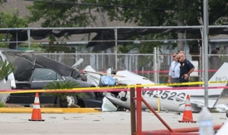 Sebuah pesawat kecil jatuh menimpa sebuah mobil di tempat parkir dekat bandara Houston, Kamis (9/6).