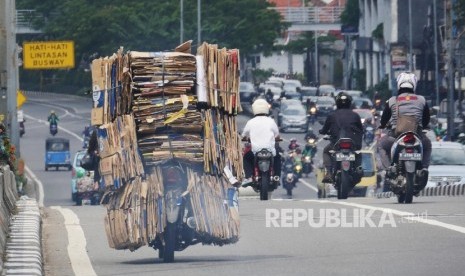  Sebuah sepeda motor dengan bermuatan tumpukan kardus bekas melintas di kisaran fly over Senen Jakarta, Selasa (4/7). 