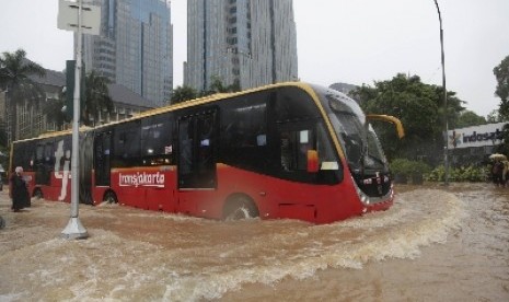 Sebuah Transjakarta menerobos banjir di Jakarta, Senin (9/2).