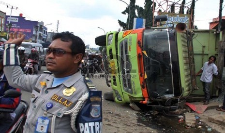    Sebuah truk bermuatan batu koral terguling di Jalan Raya Ciputat, Tangerang Selatan, Rabu (28/11).   (Republika/Yasin Habibi)