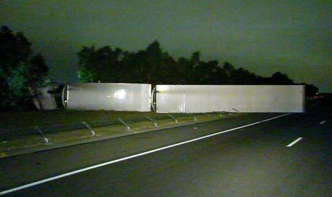 Sebuah truk gandeng membawa nugget ayam terguling ke samping setelah tabrakan di Hume Freeway, Melbourne, 6 April 2018.