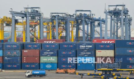 Sebuah truk melintas di depan peti kemas di pelabuhan Tanjung Priok, Jakarta Utara, Kamis (22/7/2021). 