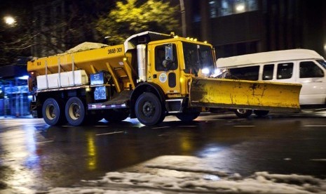  Sebuah truk membersihkan salju yang menutupi jalan di kawasan Lower East Side di New York, Rabu (8/11). (Reuters/Andrew Burton) 