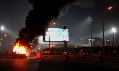 Sebuah truk terbakar akibat bentrok pasukan keamanan Mesir dengan pendukung klub Zamalek di luar Air Defense Stadium di Kairo, Mesir, Ahad (8/2)