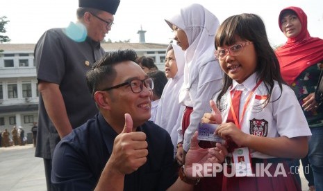 Secara simbolis Wali Kota Bandung Ridwan Kamil menyerahkan kartu Bandung Juara kepada sejumlah siswa, di Plaza Balai Kota Bandung, Senin (24/7).