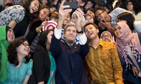 Secretary of State John Kerry (center) takes a selfie with a group of students before delivering a speech on climate change on Sunday, Feb. 16, 2014, in Jakarta, Indonesia. 