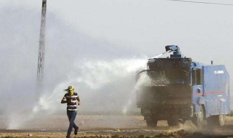 Security forces use water cannons to disperse Kurdish demonstrators at the Turkish-Syrian boder near the southeastern town of Suruc September 23, 2014, who had gathered to support Syrian Kurds.