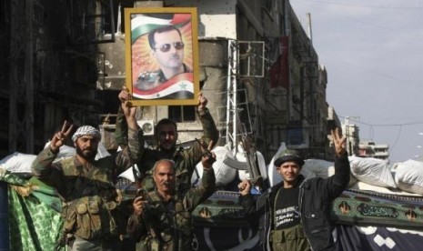 Security personnel loyal to Syria's President Bashar al-Assad flash the 'V' signs in Hujaira town, south of Damascus November 20, 2013 file photo.  