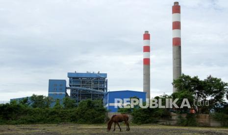 Seekor kuda mencari makan dengan latar belakang Pembangkit Listrik Tenaga Uap (PLTU) di Kabupaten Jeneponto, Sulawesi Selatan, Sabtu (12/2/2022). Pemerintah melalui Kementerian ESDM meluncurkan aturan terkait ekonomi karbon.