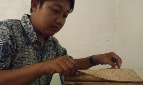 Sejarawan dan dosen Ilmu Sejarah IAIN Syekh Nurjati Cirebon, Tendi sedang membuka manuskrip Babad Sejarah Cirebon di Keraton Kacirebonan.