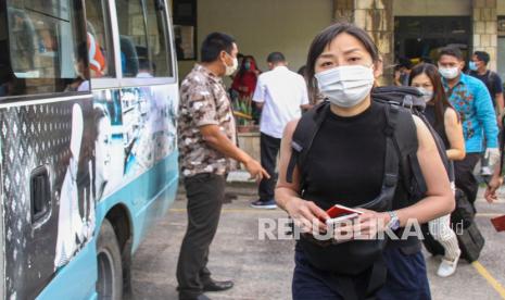 Sejumah wisatawan Singapura berjalan menuju bus pariwisata setibanya di Pelabuhan Ferry Internasional Nongsapura, Batam, Kepulauan Riau, Rabu (23/2/2022). Sebanyak 28 wisatawan mancanegara asal Singapura perdana berkunjung ke Pulau Batam untuk berwisata melalui skema gelembung perjalanan (travel bubble) yang telah dibuka pada 24 Januari 2022 lalu.