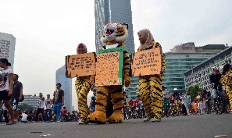 Sejumlah aktivis Greenpeace mengenakan pakaian harimau berjalan untuk mengkampanyekan perlindungan Harimau Sumatera di Bundaran HI, Jakarta, Ahad (8/12). Para aktivis mengajak masyarakat untuk ikui mendukung gerakan penyelamatan Harimau Sumatera yang saat 