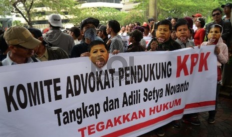 Sejumlah aktivis memakai topeng Ketua DPR Setya Novanto saat berunjuk rasa di depan Gedung Komisi Pemberantasan Korupsi (KPK), Jakarta, Selasa (24/11).