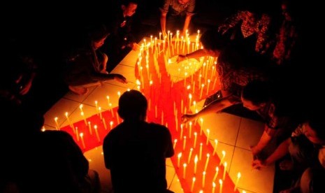 Sejumlah aktivis menyalakan lilin pada malam renungan HIV/AIDS. 