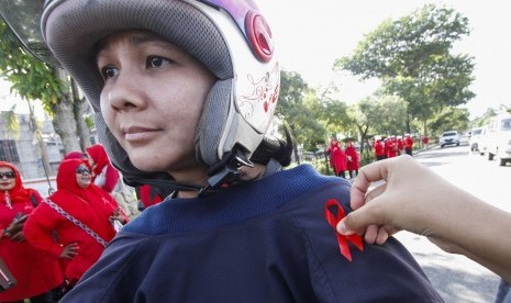 Sejumlah aktivitis Komisi Penanggulangan AIDS Pekanbaru membagikan bunga dan pita kepada pengguna jalan saat peringatan Hari AIDS Sedunia di Kota Pekanbaru, Riau, Sabtu (1/12/2018). 