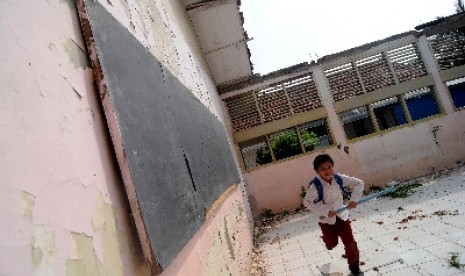 Sejumlah anak-anak bermain di ruang kelas di SDN 06 Malaka Jaya, Duren Sawit, Jakarta Timur yang tanpa atap dan rusak, Jumat (27/4). 