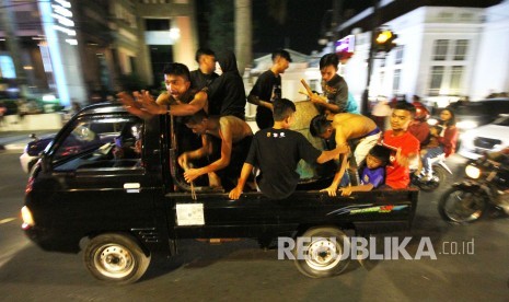 Sejumlah anak-anak dan remaja melakukan takbiran keliling melewati Jalan Asia Afrika, kawasan Alun-alun, Kota Bandung, Kamis (14/6). 