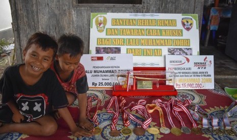 Sejumlah anak-anak melihat medali milik pelari Lalu Muhammad Zohri di rumahnya di Dusun Karang Pangsor, Pemenang Barat, Pemenang, Tanjung, Lombok Utara, NTB, Jumat (13/7).