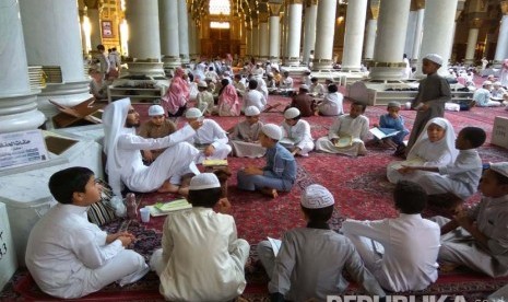 Sejumlah anak-anak tengah muroja'ah (mengulang hafalan) alquran dibimbing oleh seorang guru di masjid Nabawi.