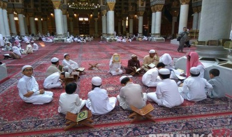 Sejumlah anak-anak tengah muroja'ah (mengulang hafalan) alquran dibimbing oleh seorang guru di masjid Nabawi.