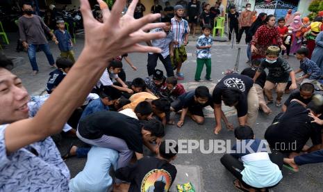 Sejumlah anak berebut uang yang dibagikan warga saat kegiatan peringatan Maulid Nabi Muhammad SAW di kawasan Kepaon, Denpasar, Bali, Selasa (19/10/2021). Warga setempat memeriahkan peringatan Maulid Nabi Muhammad SAW dengan melakukan sejumlah tradisi seperti menyusun telur yang disusun pada 