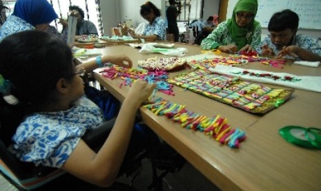 Sejumlah anak berkebutuhan khusus merangkai kalung berbahan manik-manik pada pelajaran keterampilan di Jakarta.