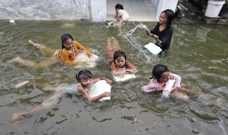 Sejumlah anak bermain air di jalan yang tergenang rob di Desa Banyuwangi, Gresik, Jawa Timur, Jumat (17/6/22). Rob akibat gelombang pasang air laut itu menggenangi kawasan tersebut sejak lima hari terakhir dan mengakibatkan beberapa rumah warga, tambak dan sekolah terendam dengan ketinggian air sekitar 15-40 centimeter. 