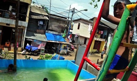  Sejumlah anak bermain air di kawasan padat penduduk di Petamburan, Jakarta, Jumat (3/1).  (Republika/Agung Supriyanto)