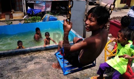  Sejumlah anak bermain air di kawasan padat penduduk di Petamburan, Jakarta, Jumat (3/1).  (Republika/Agung Supriyanto)