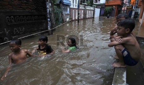 Sejumlah anak bermain air ketika banjir merendam di Petogogan, Jakarta Selatan, Selasa (10/2).(Republika/Agung Supriyanto)