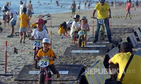 Sejumlah anak bermain balap sepeda dalam rangkaian Festival Pantai Kuta, Bali, Jumat (14/10). Festival yang digelar selama 3 hari tersebut menampilkan kesenian lokal, wisata kuliner dan berbagai kompetisi lainnya yang melibatkan para wisatawan dan pengunju