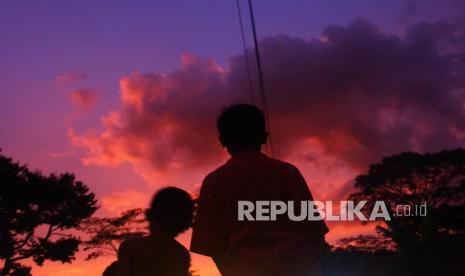 Sejumlah anak bermain dan menikmati pemandangan senja terakhir di tahun 2021 di depan pengungsian letusan gunung Semeru di SDN Supiturang 4, Pronojiwo, Lumajang, Jawa Timur.