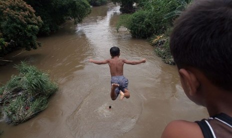 Sejumlah anak bermain dengan melompat dari atas jembatan ke Sungai Deli Medan, Sumut