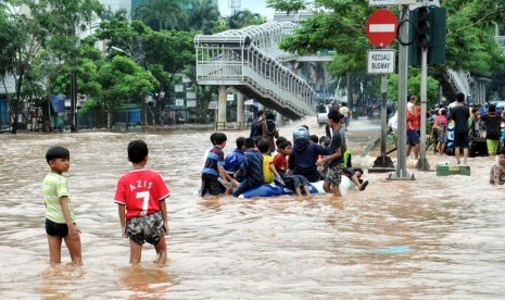  Sejumlah anak bermain di genangan air banjir di depan Perumahan Green Garden, Jakarta Barat, Rabu (11/2).  (foto : MgROL_34)