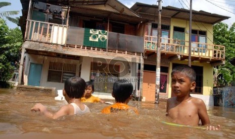  Sejumlah anak bermain di genangan air banjir yang menggenangi kawasan Kampung Melayu Kecil 1, Poncol, Bukit Duri, Jakarta Selatan,Senin (22/10).    (Agung Fatma Putra)