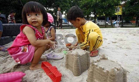   Sejumlah anak bermain patung pasir di taman interaktif di bantaran Kanal Banjir Timur, Duren Sawit, Jakarta Timur, Senin (25/3). 