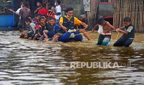 Sejumlah anak bermain perahu karet saat banjir di Ciwandan, Cilegon, Banten, Kamis (3/12). Banjir terjadi akibat hujan deras yang mengakibatkan Sungai Ciwandan meluap hingga menggenangi jalan raya Cilegon-Anyer setinggi 50 cm hingga 1 meter.