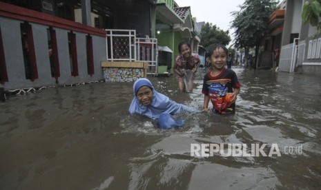 Sejumlah anak bermain saat banjir di kawasan Perumahan Tirta Mandala, Depok, Jawa Barat, Sabtu (15/2/2020). Hujan deras sejak pukul 13.00 mengakibatkan ratusan rumah di Depok terendam banjir.