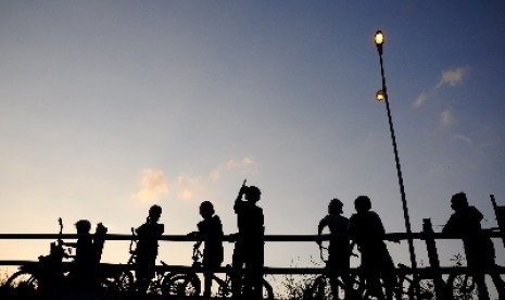 Sejumlah anak bermain sepeda di jalan lingkar utara (jalingkut) Tegal, Jawa Tengah sambil menunggu waktu berbuka puasa (ngabuburit). 